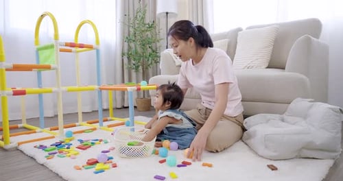 Woman and Baby Play with Toys in Living Room