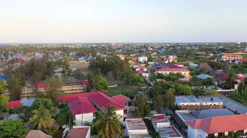 Aerial perspective captures a bustling coastal town with colorful buildings and beautiful ocean.