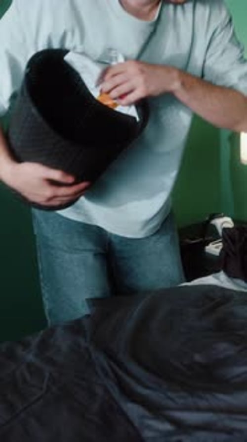 Man Collecting Trash in Home Interior