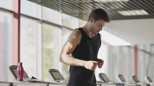 Fitness Man Running on Treadmill Machine in Gym Club. Handsome Sportsman Training