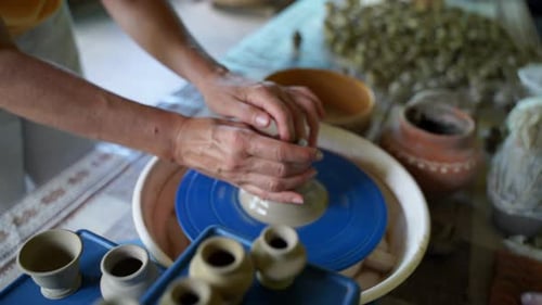 Close Up of Hands of Two Women Pottering One Learning Another on a Potter's Wheel Modelling a