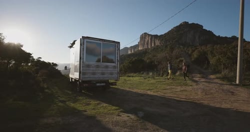 Couple Opening The Camper Van Parked On A Field On Sunny Day. medium shot
