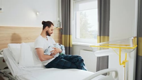 Happy Fathers Gently Holding His Lovely Cute Newborn Baby Boy in Hospital Room