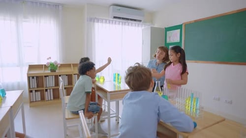 Adorable student learn with teacher in classroom at elementary school.