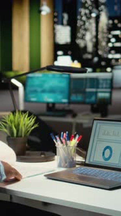 Vertical Video Male Office Worker Fact Checking Numbers and Finance Data Metrics at Night