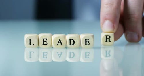 Slow motion macro of the word "Leader" of the wooden letter blocks . Concept of financial market a