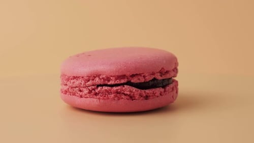 Rotating Colorful French macaroons on an orange background.