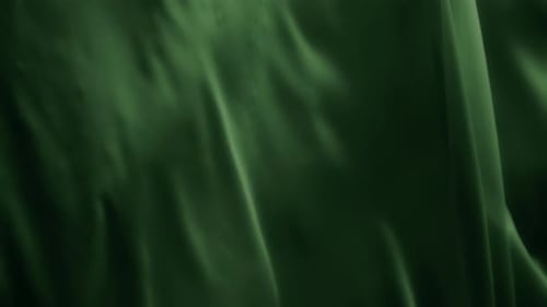 Green chiffon textile waving in the wind. Abstract texture background.