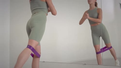 Woman Working Out with Resistance Band at Home