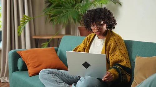 African American Girl Using Laptop at Home Office Looking at Screen Typing Chatting Reading Writing
