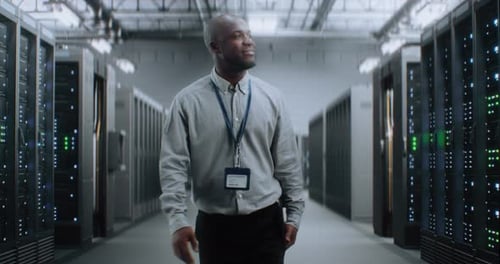 Big Data Center with Server Racks and Internet Servers Specialist Walking In Warehouse