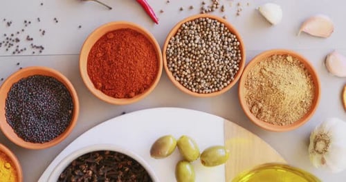 Curry, herbs and spices on table in kitchen for cooking, food or seasoning collection with color