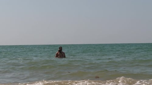 Father and Child Playing on Beach in Water