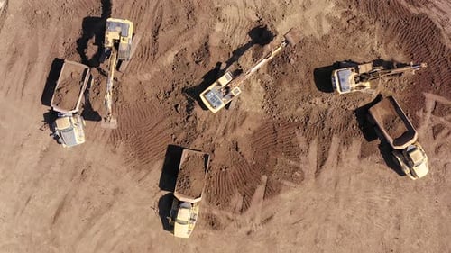 Excavators Loading Dump Trucks with Dirt Aerial View
