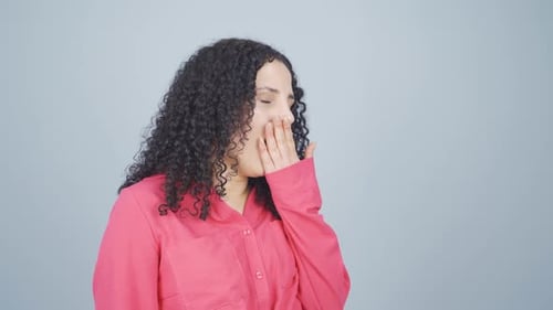 Une jeune femme endormie bâille.