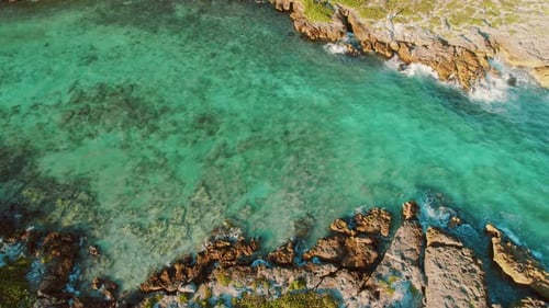 Aerial view of rocky tropical shoreline with turquoise sea crystal clear water