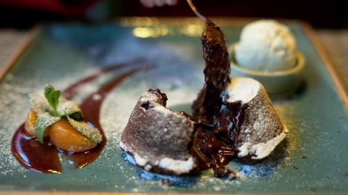 Chocolate lava cake with ice cream and orange decoration in a restaurant