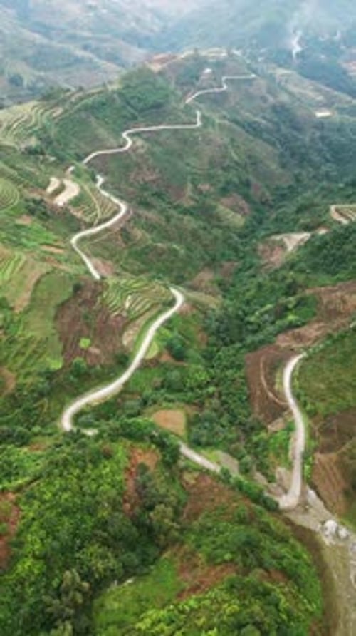 Vue verticale par Drone d'une route sinueuse traversant des collines en terrasses dans les hauts plateaux du nord du Vietnam