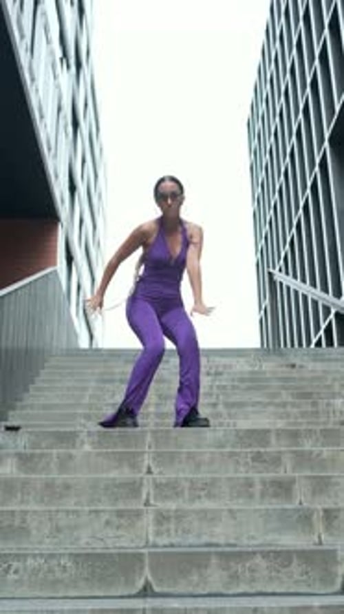 Young Woman Dancing on Concrete Steps in City