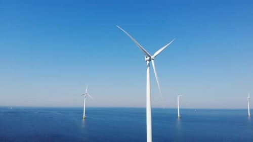 Offshore Windmill Park with Clouds and a Blue Sky