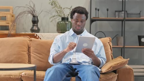Man Using Tablet on Sofa in Living Room