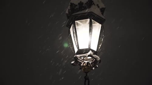Snowflakes illuminated by bright light in park.