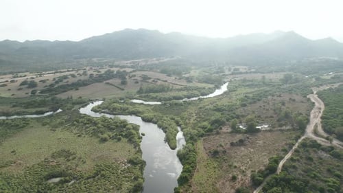 Aerial top down view drone over river going into the sea. Beach sand, rock formations and amazing se