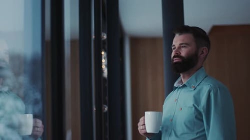 Young Handsome Man Bearded Happy Drinking Coffee and Enjoying View From Window Relax Handsome Male