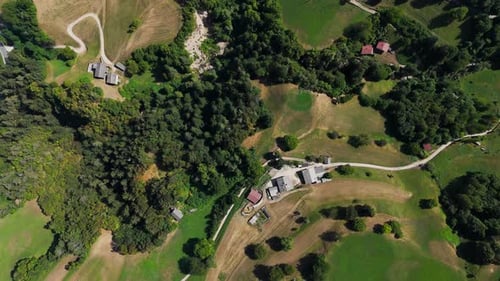 Camera panning over beautiful green farmland showing farm