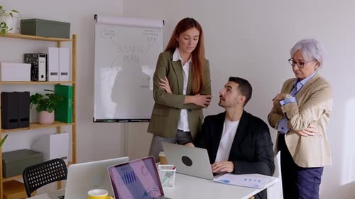 Three Business People Working Together on Laptop in the Office