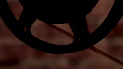 Silhouette of a close-up film reel spinning with visible film strip.