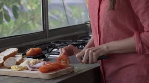 Woman slices tomatoes on cutting board at home