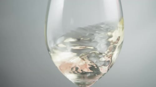 Vin blanc ondulant dans un verre à vin