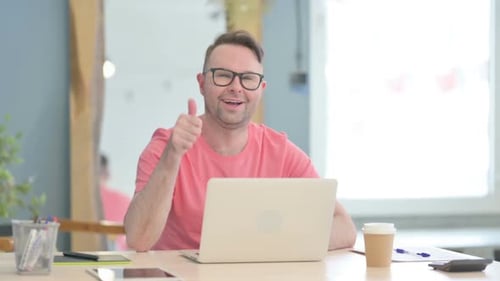 Man with Laptop Gives Thumbs Up