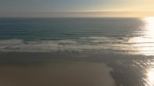 Vue aérienne en haute altitude de la plage et des vagues au coucher du soleil. Drone statique