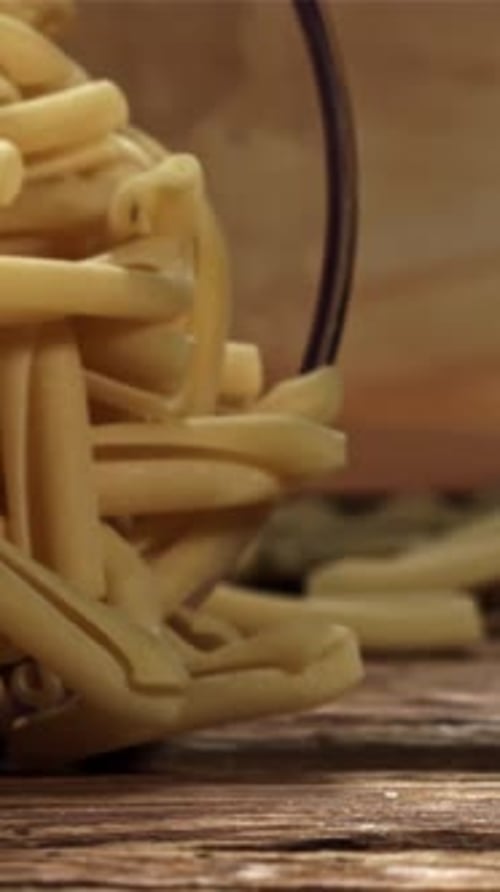 Dry Pasta Falls on a Wooden Table Filmed on a Highspeed Camera at 1000 Fps