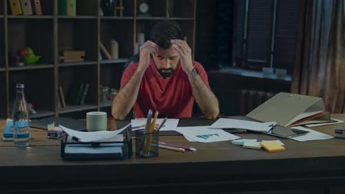 Hombre de negocios cansado en una oficina acogedora. Joven empresario cansado en el trabajo nocturno