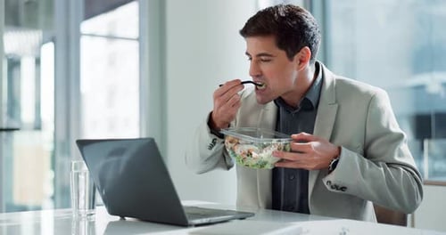 Man Eating Salad While Working at Computer