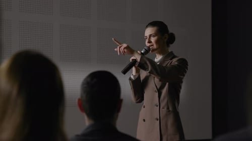 Woman Giving Presentation to Audience at Conference