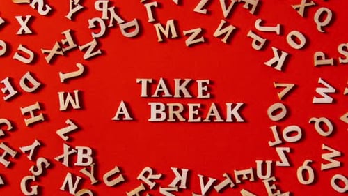 Zoom in Out Quote TAKE A BREAK Made Out of Wooden Letters on Bright Red Background