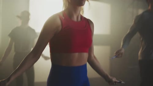 Athletic People Exercising with Jump Ropes in Gym