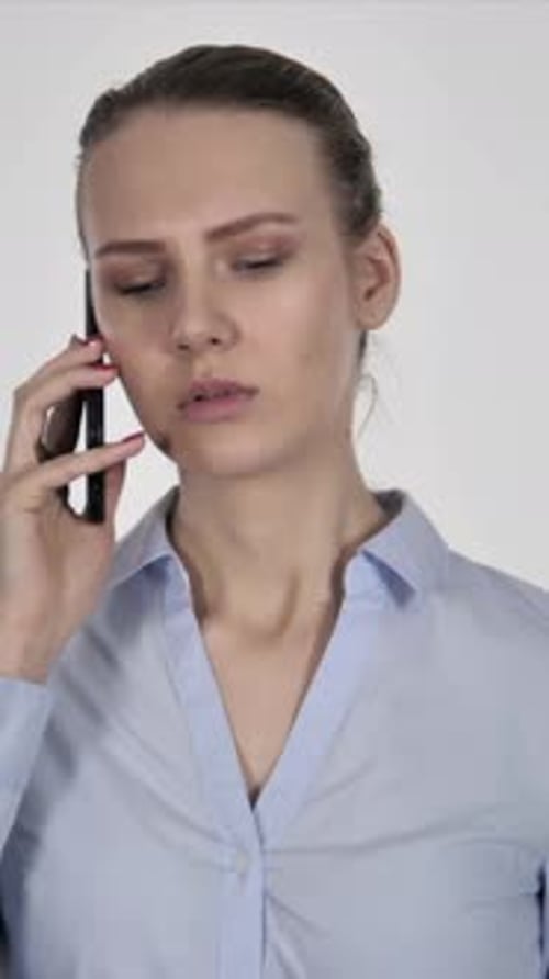 Serious Woman Talking on Phone in Studio Setting