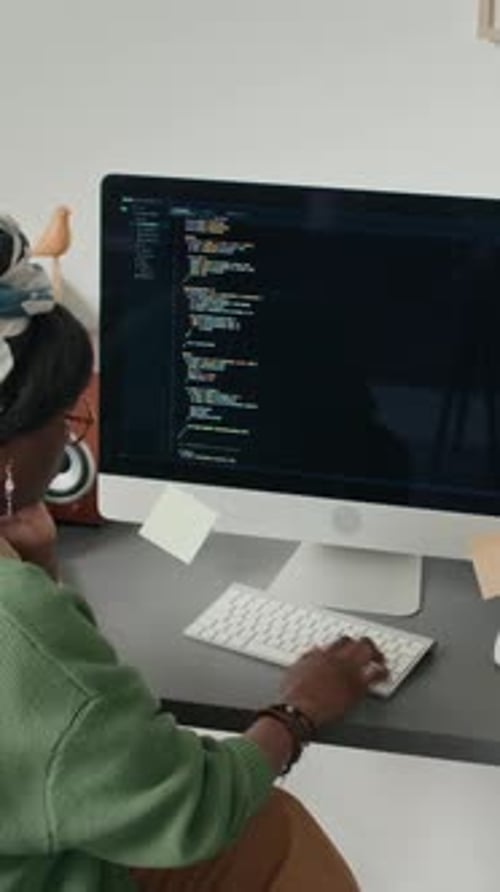 Femme afro-américaine codant sur ordinateur au bureau