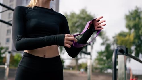 Close-up of a girl performing exercises with elastic bands to strengthen her arm muscles training