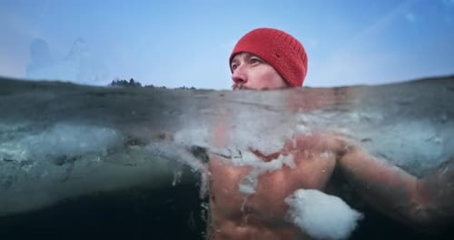 Portrait d'un nageur hivernal, traitement par le froid. Un jeune homme se baigne dans le lac glacé d'hiver puis tourne la tête