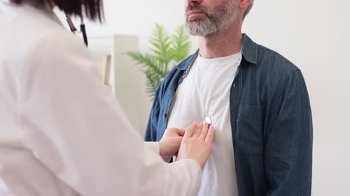 Therapist Hearing Man's Heartbeat Via Stethoscope in Clinic