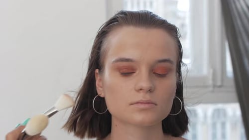 Makeup Artist Applying Makeup to Model's Face Close Up View