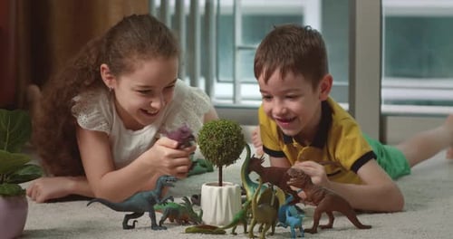 Children Play with Toys Cute Brother and His Sister Play Lying on the Warm Floor at Home Happy