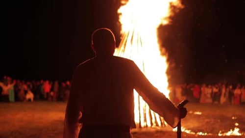 Silhouette eines Mannes vor einem großen Lagerfeuer Traditionen und Bräuche des slawischen Volkes