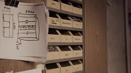 Armoire de rangement avec croquis de meubles sur mur dans un atelier de menuiserie